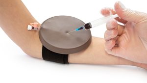 ACF Pad in a dark skin tone being used to train in venipuncture